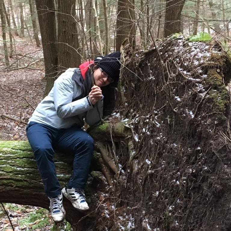 Yen embracing a fallen tree stump.