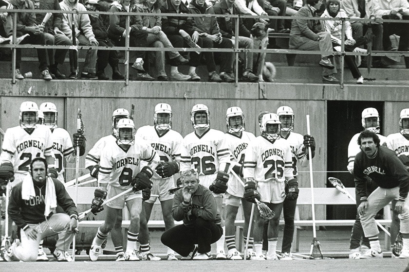 Lacrosse team members on the sideline during a game