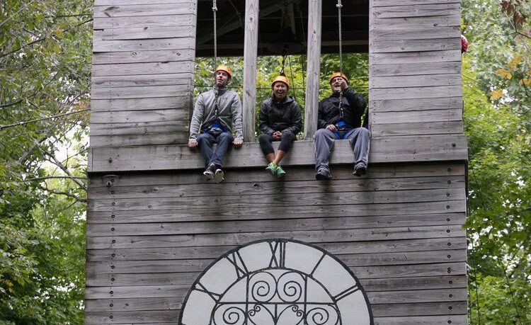 Students participate in a ropes course challenge.