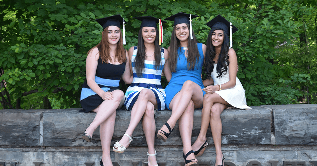 graduates in graduation caps pose for a picture
