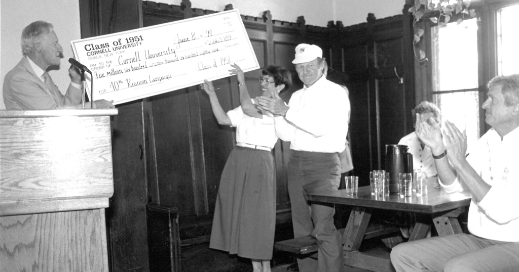 Mibs holds up a large check at an event