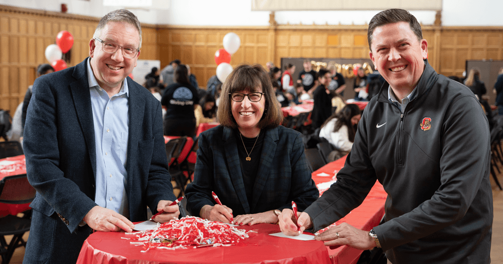 Fred Van Sickle, vice president for Alumni Affairs and Development, Martha E. Pollack, president of Cornell University, and Ryan Lombardi, vice president for Student & Campus Life, pose for a picture together after writing thank-you postcards to Giving Day donors