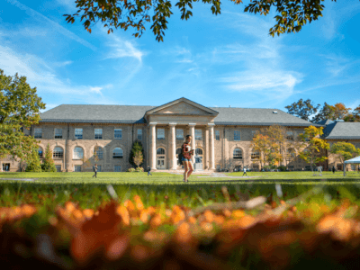 A student walks through the Arts Quad on a sunny day