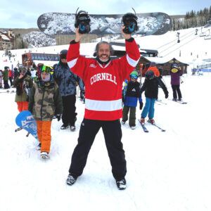Enrique enjoys snowboarding in his Cornell gear