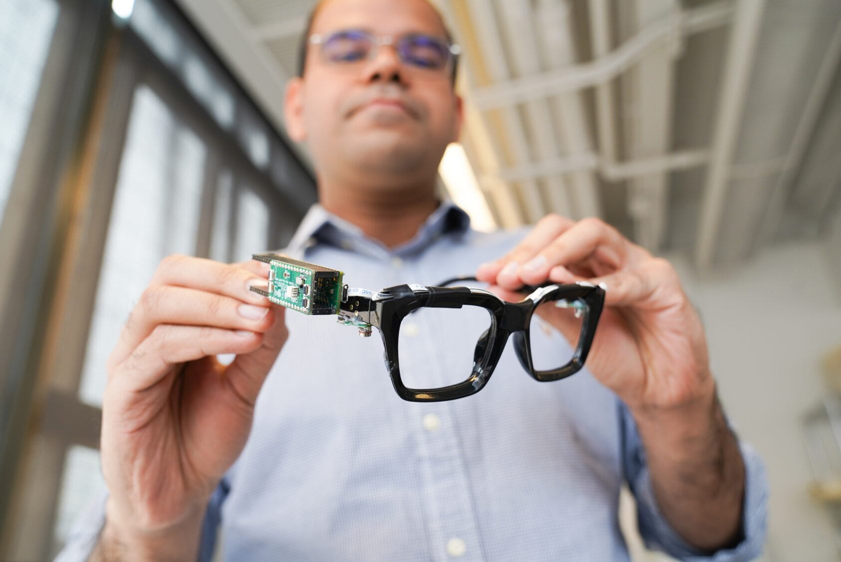 Saif Mahmud, a doctoral student in the field of information science, with PoseSonic glasses.