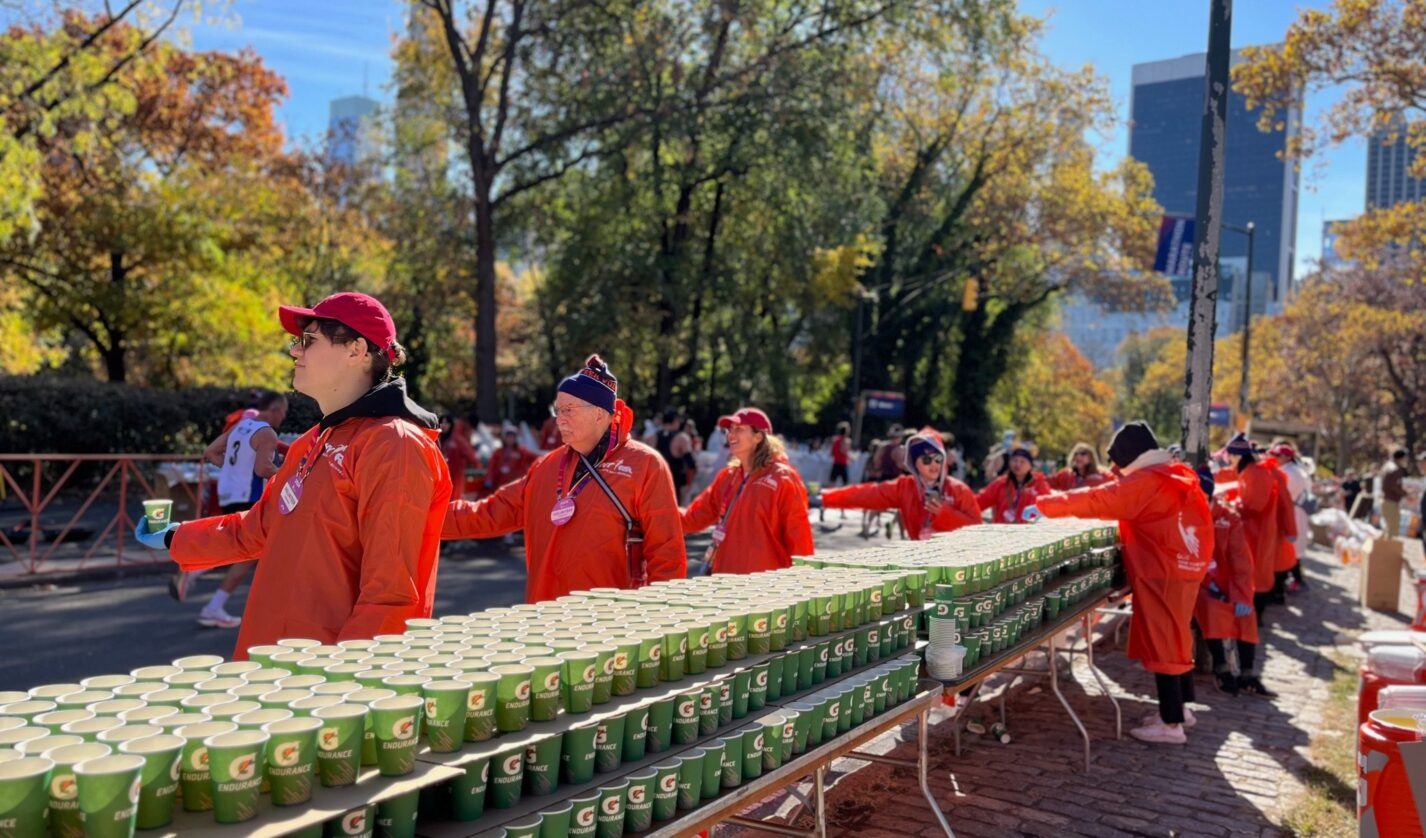 Members of NYC Cornellians provide handing out water cups at the 2024 New York City Marathon.