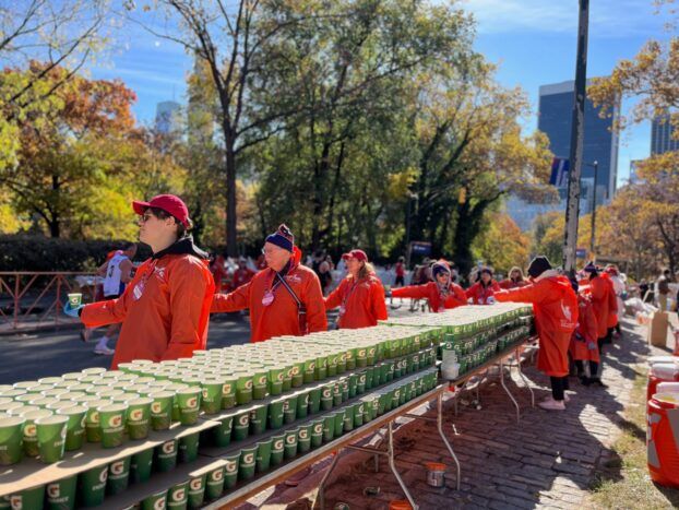 Members of NYC Cornellians provide handing out water cups at the 2024 New York City Marathon.