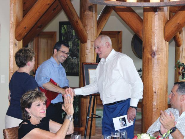 George Gellert ’60, MBA ’62, JD ’63 (right) congratulates Martin Wiedmann PhD ’97 (left in blue shirt) at a 2017 event dedicating the Gellerts’ gift to establish the Gellert Family Professorship in Food Safety.