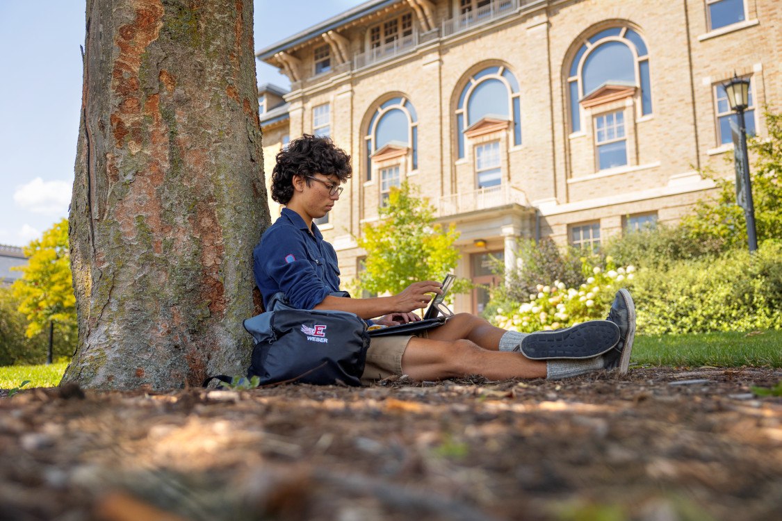 A CALS student works outside near the CCC Building on the Arts Quad.