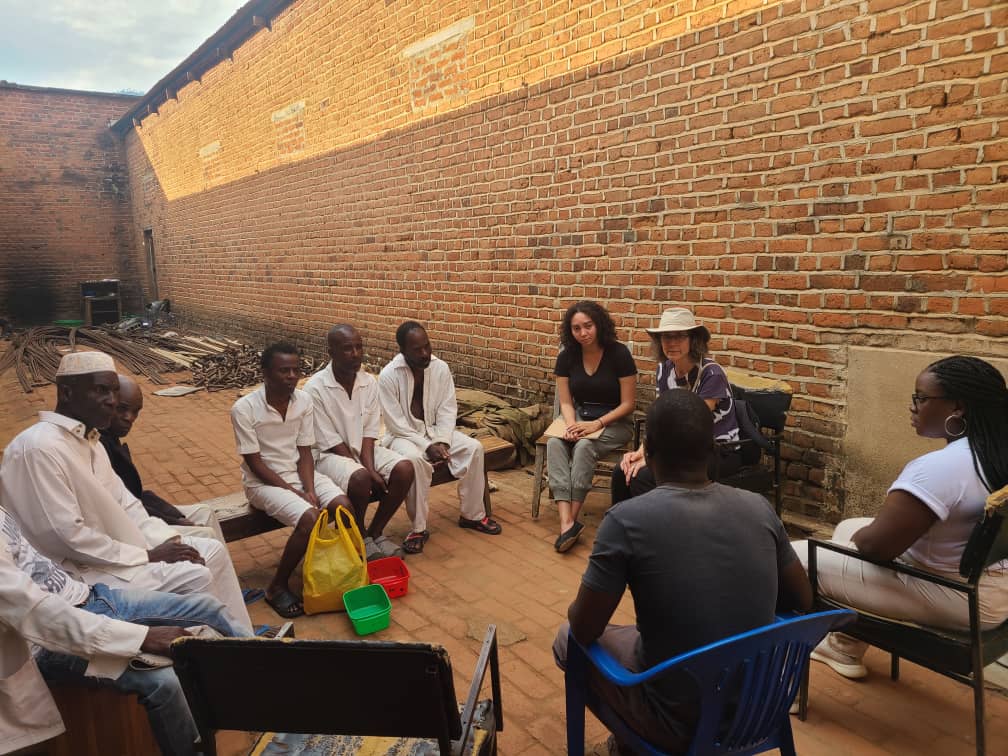 International Human Rights Clinic students Merrick Black JD ’24 and Nkemdirim Obodo JD ’24, together with Professor Sandra Babcock and clinic partner Chipiliro Lulanga, provide a legal briefing to six clinic clients in Malawi’s Zomba prison.