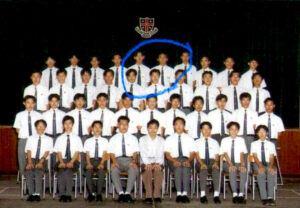 Isaac (wearing glasses in blue circle) in his 1996 high school graduation photo